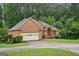 Red brick home with attached garage and circular driveway at 1214 Lambeth Se Way, Conyers, GA 30013