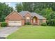 Charming brick home with well-manicured lawn and attached two-car garage at 1214 Lambeth Se Way, Conyers, GA 30013