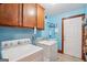 Bright laundry room features a washing machine, dryer, sink, storage cabinets and access to exterior at 1214 Lambeth Se Way, Conyers, GA 30013