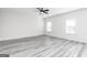 Spacious bedroom with gray wood-look floors, a ceiling fan, and natural light from two large windows at 3392 Arabian Farm Ln, Dacula, GA 30019