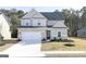 Charming two-story home featuring a brick and gray exterior, a two-car garage, and a well-manicured front yard at 3392 Arabian Farm Ln, Dacula, GA 30019