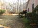 Large backyard featuring mature trees, shrubs, and a manicured lawn that provides ample space for outdoor activities at 5848 Navarre Ct, Stone Mountain, GA 30087
