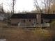 View of the house's back exterior and deck overlooking a spacious backyard with mature trees at 5848 Navarre Ct, Stone Mountain, GA 30087