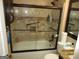 Bathroom featuring a shower/tub combo with sliding glass doors and tiled walls with accent tiles at 5848 Navarre Ct, Stone Mountain, GA 30087
