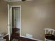 Cozy bedroom features hardwood floors, neutral walls, and a glimpse into an adjacent room through an open doorway at 5848 Navarre Ct, Stone Mountain, GA 30087