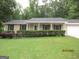 Charming single-story home with manicured lawn, trimmed bushes, and a welcoming front porch at 5848 Navarre Ct, Stone Mountain, GA 30087
