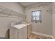 Functional laundry room equipped with a washer, dryer, wire shelving, and natural light at 3112 Patriot Sq, Marietta, GA 30064