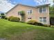 Back of the home featuring multiple windows and a well-manicured lawn with trimmed shrubs at 133 Sea Island Dr, Peachtree City, GA 30269