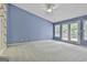 A spacious carpeted bedroom with vaulted ceiling and doors to the outside at 133 Sea Island Dr, Peachtree City, GA 30269