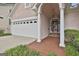 Home exterior featuring a two-car garage, arched entryway, and lush landscaping at 133 Sea Island Dr, Peachtree City, GA 30269