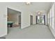 Open living room with neutral carpet, trim, and walls, a view into adjacent rooms, and a ceiling fan at 133 Sea Island Dr, Peachtree City, GA 30269
