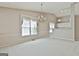 Open living room with a chandelier, carpet flooring, and large windows, creating a bright and inviting space at 133 Sea Island Dr, Peachtree City, GA 30269