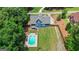 Aerial view of a large backyard featuring a pool, well-manicured lawn, and a blue two-story home at 150 Surrey Chase Dr, Social Circle, GA 30025