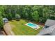 Aerial shot of the backyard with a sparkling pool, lush lawn, and a detached garage, ideal for outdoor living at 150 Surrey Chase Dr, Social Circle, GA 30025