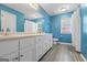 Bright bathroom with double vanity, shaker cabinets, a large mirror, and stylish wood-look floors at 150 Surrey Chase Dr, Social Circle, GA 30025