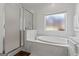 Bathroom featuring a soaking tub, frosted windows and a glass enclosed shower at 150 Surrey Chase Dr, Social Circle, GA 30025