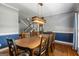 Formal dining room with decorative wood table, hardwood floors, and modern light fixture at 150 Surrey Chase Dr, Social Circle, GA 30025