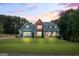 Charming two-story home featuring a brick facade, blue siding, lush lawn, and manicured landscaping at 150 Surrey Chase Dr, Social Circle, GA 30025