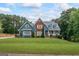 Beautiful two-story home with a well-maintained lawn, red brick and blue siding, and lovely landscaping at 150 Surrey Chase Dr, Social Circle, GA 30025
