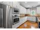 Modern kitchen with stainless steel appliances, white cabinets, hardwood floors, and light countertops for a bright and airy feel at 150 Surrey Chase Dr, Social Circle, GA 30025