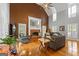 Comfortable living room featuring a vaulted ceiling, fireplace, hardwood floors, and large windows with bright, natural light at 150 Surrey Chase Dr, Social Circle, GA 30025