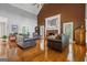Spacious living room with a soaring ceiling, exposed beams, brick fireplace, and large windows that offer natural light at 150 Surrey Chase Dr, Social Circle, GA 30025