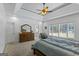 Main bedroom with ceiling fan, large windows, and a stylish dresser with mirror at 150 Surrey Chase Dr, Social Circle, GA 30025