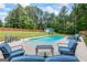 Backyard pool with outdoor seating, large grassy area, wooden fence, and a storage shed at 150 Surrey Chase Dr, Social Circle, GA 30025