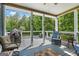 Covered porch area with ceiling fan, railings, seating and view of backyard trees at 150 Surrey Chase Dr, Social Circle, GA 30025
