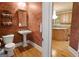 Stylish half-bathroom with decorative painted walls, pedestal sink, and modern fixtures, conveniently located near the kitchen at 1014 Overlook Dr, Villa Rica, GA 30180