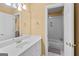 Bright bathroom featuring a white sink, vanity and a view of the shower/bath with tiled walls at 1014 Overlook Dr, Villa Rica, GA 30180