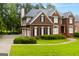 Brick home featuring a manicured lawn, a three car garage and a classic architectural design with black shutters at 1014 Overlook Dr, Villa Rica, GA 30180