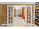 Hallway with neutral tile flooring and a view into the bedroom/bathroom through glass-paneled French doors at 1014 Overlook Dr, Villa Rica, GA 30180