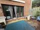 Exterior back patio with brick wall, chair, sliding glass doors, and foliage at 3346 Northcrest Rd # A, Atlanta, GA 30340