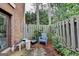 Private outdoor patio area with worn wood fence, foliage, and an exterior view of trees at 3346 Northcrest Rd # A, Atlanta, GA 30340