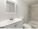 Bright bathroom featuring a white vanity, toilet, framed mirror and walk-in shower with tiled walls at 4651 Garden Hills Dr, Stone Mountain, GA 30083