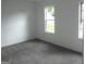 Clean and minimalist bedroom featuring neutral walls, plush carpet, and ample natural light at 4651 Garden Hills Dr, Stone Mountain, GA 30083