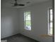 A bedroom with carpet features a ceiling fan and two windows providing natural light at 4651 Garden Hills Dr, Stone Mountain, GA 30083