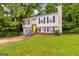 Charming split-level home featuring a bright yellow door, black shutters, and lush green landscaping at 4651 Garden Hills Dr, Stone Mountain, GA 30083