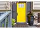 Charming yellow front door with black shutters, potted plants, and a welcome mat at 4651 Garden Hills Dr, Stone Mountain, GA 30083