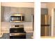 Stylish kitchen featuring stainless steel appliances, grey cabinets, and sleek countertops at 4651 Garden Hills Dr, Stone Mountain, GA 30083