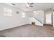 A bright living room with carpeted floors, fan, staircase and several windows at 4651 Garden Hills Dr, Stone Mountain, GA 30083