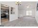 Open living space with gray carpet, ceiling fan and view into kitchen with stainless steel appliances at 4651 Garden Hills Dr, Stone Mountain, GA 30083
