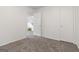 An empty carpeted room with a ceiling fan, doorway, and a staircase at 4651 Garden Hills Dr, Stone Mountain, GA 30083