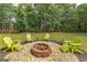 Backyard showing a brick fire pit surrounded by gravel and green chairs at 715 Branchview Ct, Mcdonough, GA 30252