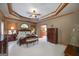 Spacious main bedroom featuring a tray ceiling, a ceiling fan and carpet flooring at 715 Branchview Ct, Mcdonough, GA 30252
