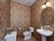 Classic powder room featuring floral wallpaper, a pedestal sink, and a toilet at 715 Branchview Ct, Mcdonough, GA 30252