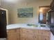 View of the kitchen island, refrigerator and a painting of boats, blending style and functionality in cooking area at 1470 Dunn Rd, Cumming, GA 30040