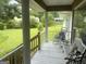 Relaxing porch features seating with a bench, rocking chair and picturesque view of the expansive lawn at 1470 Dunn Rd, Cumming, GA 30040