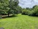 Well-maintained lawn surrounded by lush greenery and mature trees, offering a private and serene outdoor space at 1470 Dunn Rd, Cumming, GA 30040